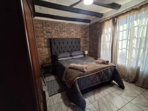 a bedroom with a bed and a brick wall at Bushveld Bliss in Marloth Park +15 photos
