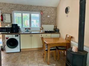 a kitchen with a table and a washing machine at Padoro Lodge in Kildare