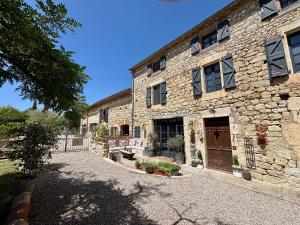 a stone building with a bench in front of it at Maison Mûrier in Fayssac