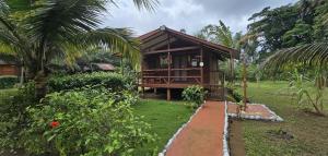 a small house in a garden with a walkway at Gombela Ecolodge and Farming in São Tomé