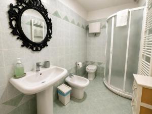 a bathroom with a sink and a toilet and a mirror at All'Ombra della Torre a due passi da Piazza del Campo in Siena