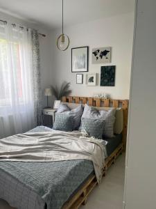 a bedroom with a bed with a wooden headboard at Zacisze na Wspólnej in Bolszewo