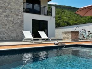 a house with two chairs and a swimming pool at Villa Harmonia in Glavati