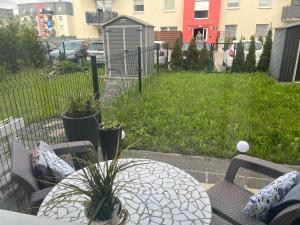 a patio with a table and chairs and a yard at Zacisze na Wspólnej in Bolszewo
