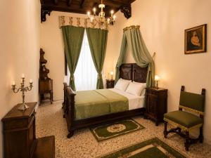a bedroom with a bed and a chair and a window at All'Ombra della Torre a due passi da Piazza del Campo in Siena