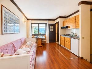 a living room with a couch and a kitchen at Hostdomus - B3-03 in Grange Sises