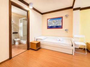 a room with a bed and a toilet and a mirror at Hostdomus - B3-03 in Grange Sises +4 photos