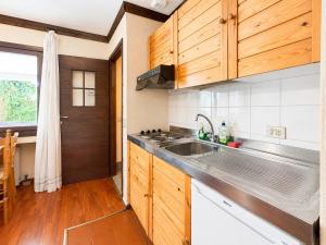 a kitchen with wooden cabinets and a sink at Hostdomus - B3-03 in Grange Sises