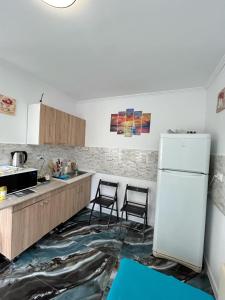 a kitchen with two chairs and a refrigerator at Căsuța de vacanță in Năvodari