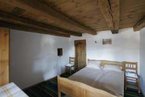 1 dormitorio con cama y techo de madera en Kruchma Bratyata Guest House en Kovačevica