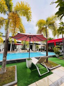 a chair and an umbrella next to a pool at Villa Abadi Resort VAR in Pantai Kok