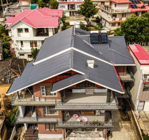 an overhead view of a house with a black roof at Lofted Peaks in Pālampur
