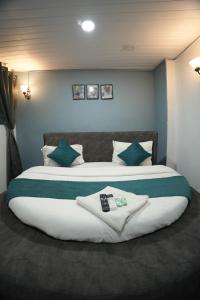 a bedroom with two beds with green and white pillows at The Highstreet Legacy in Pune