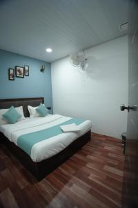 a bedroom with a large bed with blue walls at The Highstreet Legacy in Pune