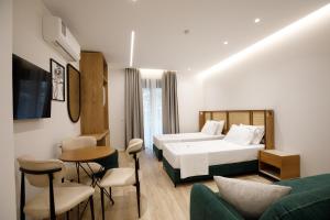 a hotel room with a bed and a table and chairs at Oleva Sea View Suites in Sarandë