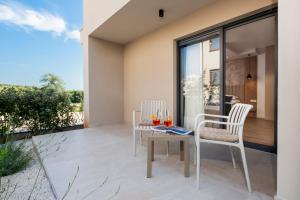 a patio with two chairs and a table on a balcony at Asterias Residence - New Opening 2026 in Rovinj