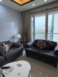 a living room with two couches and a table at 1BR Luxury Apartments With Balcony & Mountains View In Elysium Tower OPP Centaurus Mall Islamabad in Islamabad