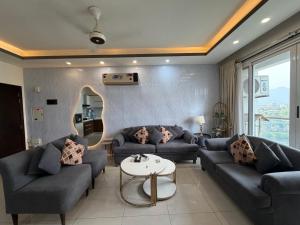 a living room with two couches and a table at 1BR Luxury Apartments With Balcony & Mountains View In Elysium Tower OPP Centaurus Mall Islamabad in Islamabad +62 photos