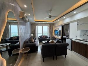 a large living room with couches and a kitchen at 1BR Luxury Apartments With Balcony & Mountains View In Elysium Tower OPP Centaurus Mall Islamabad in Islamabad