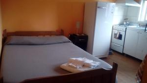 a bedroom with a bed and a kitchen with a refrigerator at B&B Guale in Gualeguaychú