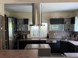a kitchen with black cabinets and a stainless steel refrigerator at Chata U Druhé pískovny in Roudná