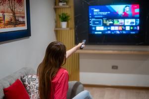 a young girl sitting on a couch playing a video game at Apartamentos WANCA SUITES para 4, 5 y 6 huéspedes cochera muy cerca al Centro in Huancayo