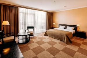 a hotel room with a bed and a table at Lavina Park Hotel in Dnipro