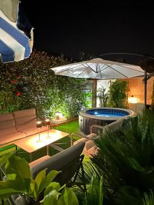 a patio with a table and an umbrella and a pool at Maria Home Reall's in Braga