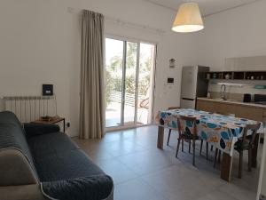 a living room with a table and a kitchen at Mondello Felix - appartamenti in villa a 600m dal mare in Mondello
