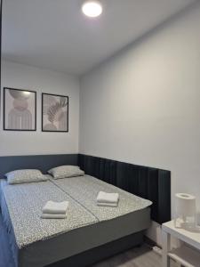 a bedroom with a bed with two towels on it at Studio Apartman 47A in Valjevo