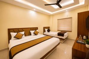a bedroom with two beds and a ceiling fan at Hotel RK Palace Vrindavan - Near Bankey Bihari and Prem Mandir in Vrindāvan
