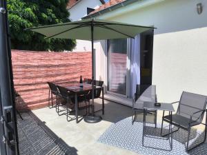 a patio with a table and chairs and an umbrella at Une pause à Magny appartement de 51 m2 proche Beaune et Dijon NETFLIX gratuit in Magny-lès-Villers