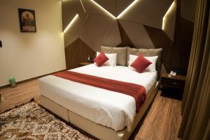a hotel room with a large bed with red pillows at Jas Grand Homes in Cochin