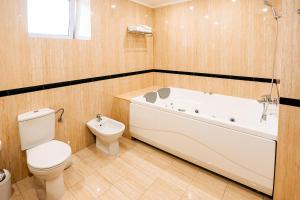 a bathroom with a toilet and a bath tub and a toilet at Lavina Park Hotel in Dnipro