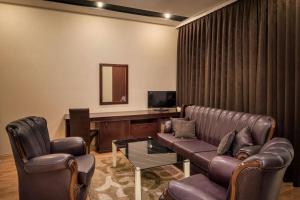 a living room with a couch and chairs and a television at Hotel XXL in Ferizaj
