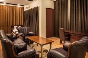 a waiting room with leather chairs and a piano at Hotel XXL in Ferizaj