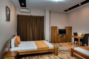 a bedroom with a bed and a desk and a television at Hotel XXL in Ferizaj