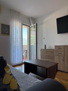 a living room with a coffee table and a television at Apartman sa pogledom na more Budva in Budva