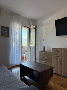 a living room with a coffee table and a television at Apartman sa pogledom na more Budva in Budva