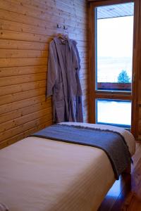 a bedroom with a bed and a coat hanging on a wall at Silmaļi Tērvetē in Tērvete