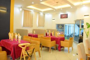 a dining room with red tables and yellow chairs at Diamond Luxury Hotel plc in Desē