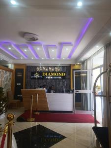 a lobby with a sign on the wall and purple lights at Diamond Luxury Hotel plc in Desē