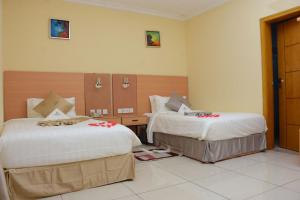 a hotel room with two beds with flowers on them at Diamond Luxury Hotel plc in Desē