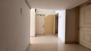 an empty hallway with white walls and a white door at Preet Residency Homestays in Jabalpur