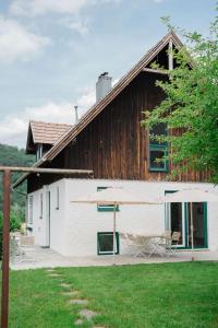 a white building with chairs and a barn at Schmidsdorf 67 in Payerbach