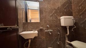 a bathroom with a sink and a toilet and a mirror at Preet Residency Homestays in Jabalpur