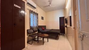 a living room with a couch and a table and chairs at Preet Residency Homestays in Jabalpur +2 photos