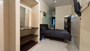 a small room with a bed and a sink at Preet Residency Homestays in Jabalpur