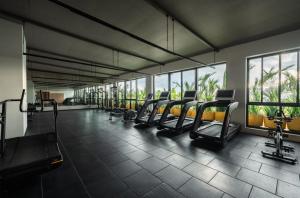 a gym with a row of treadmills and chairs at The Canvas Loft-Manyata Tech Park-Orchid Parc in Bangalore