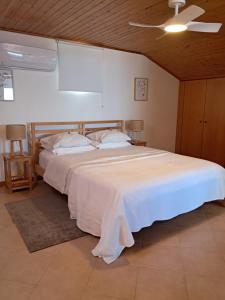 a bedroom with a large white bed with a ceiling at Casa Vida Alegre in Prazeres